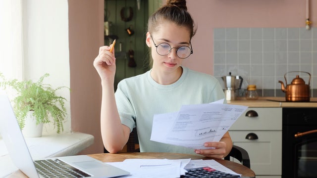 Indoor picture of young European female sitting at home at table 