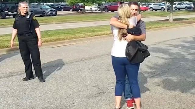 People embrace after being evacuated from a building by police in this still image taken from video following a shooting incident at the municipal center in Virginia Beach 