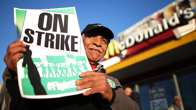 Rogelio Hernandez holds up a sign as protesters call for a minimum wage of $15 an hour during a demonstration in Los Angeles 