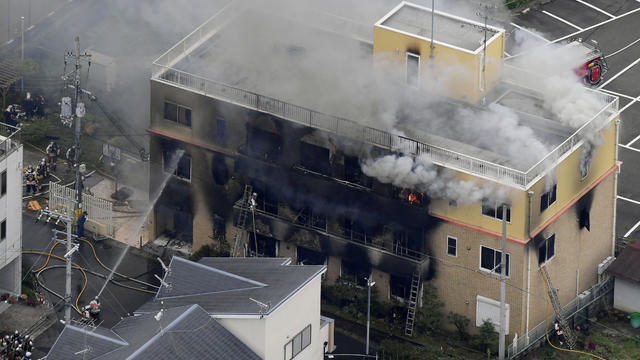 An aerial view shows firefighters battling fires at the site where a man started a fire after spraying a liquid at a three-story studio of Kyoto Animation Co. in Kyoto, western Japan, in this photo taken by Kyodo 