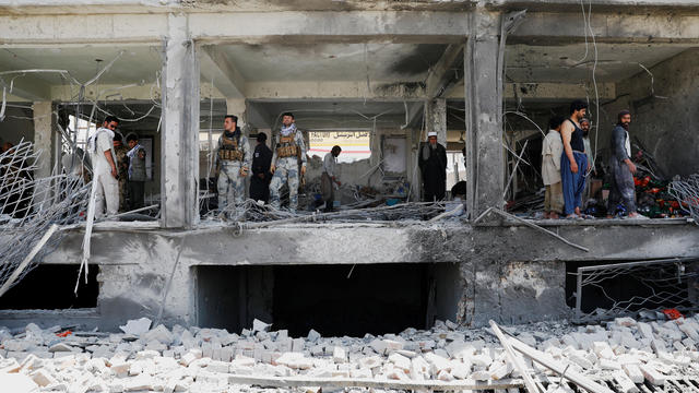 Afghan security forces inspect a damaged building at the site of a blast in Kabul, Afghanistan 