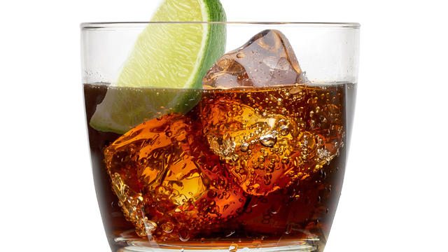 Cuba libre rum cocktail with ice cubes isolated on white background 