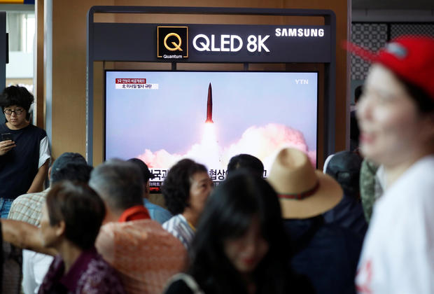 People watch a TV showing a file picture of a North Korean missile for a news report on North Korea firing short-range ballistic missiles, in Seoul 