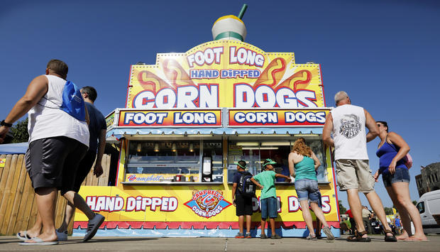 Fairgoers line up to get a corn dog at a concession stand during the opening day of the Iowa State Fair in Des Moines, Iowa, Aug. 9, 2018. 