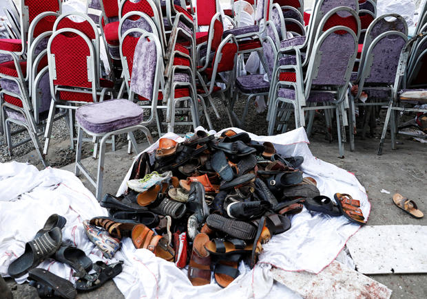 The shoes of victims are seen outside a damaged wedding hall after a blast in Kabul, Afghanistan 