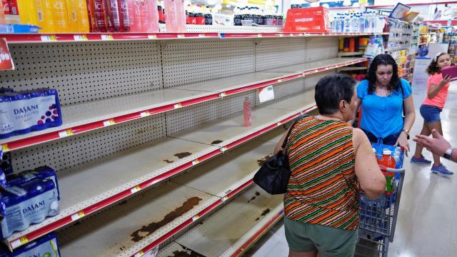 Nearly empty shelves where bottled water is normally displayed, are shown at a grocery store as Tropical Storm Dorian approaches in Cabo Rojo 