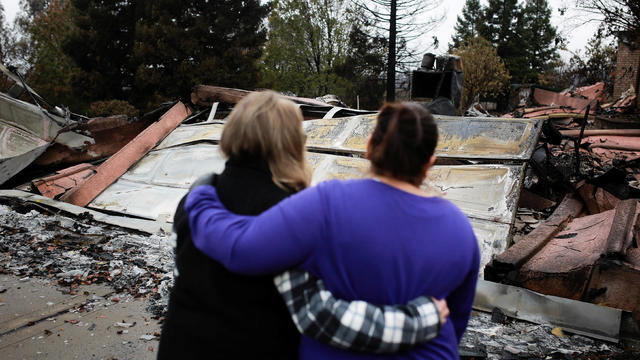 Irma Corona comforts neighbor Gerryann Wulbern in front of the remains of Wulbern's home after the two returned for the first time since the Camp Fire in Paradise 