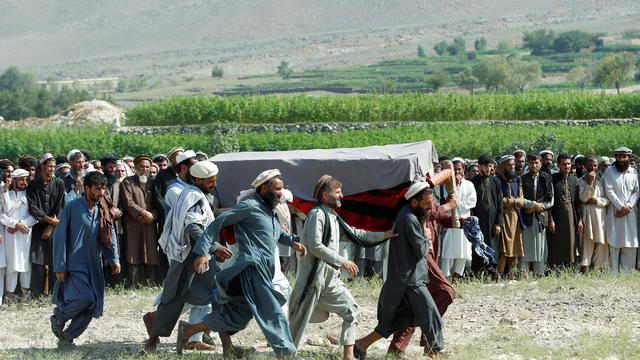 Men carry a coffin of one of the victims after a drone strike, in Khogyani district of Nangarhar province, Afghanistan 