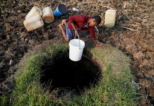 A woman fetches water from a well in Warren Park suburb, Harare 