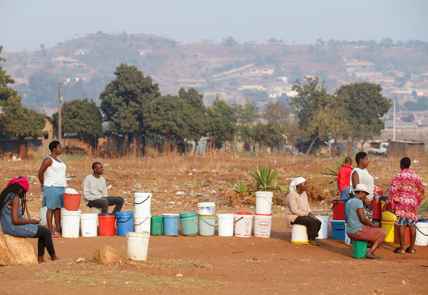 Locals wait for their turn to collect water from a borehole in Warren Park, Harare 