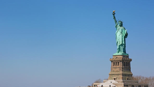 Statue of liberty and people queued for the visit 