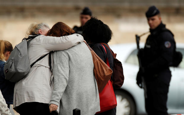People hug as they leave Paris police headquarters in Paris, France, October 3, 2019. 