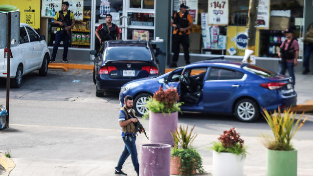 Cartel gunmen are seen outside during clashes with federal forces following the detention of Ovidio Guzman, son of drug kingpin Joaquin "El Chapo" Guzman, in Culiacan 