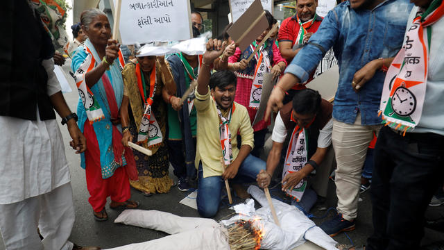 Supporters of India's main opposition Congress party burn an effigy as they shout slogans during a protest against the alleged rape and murder of a 27-year-old woman, in Ahmedabad 