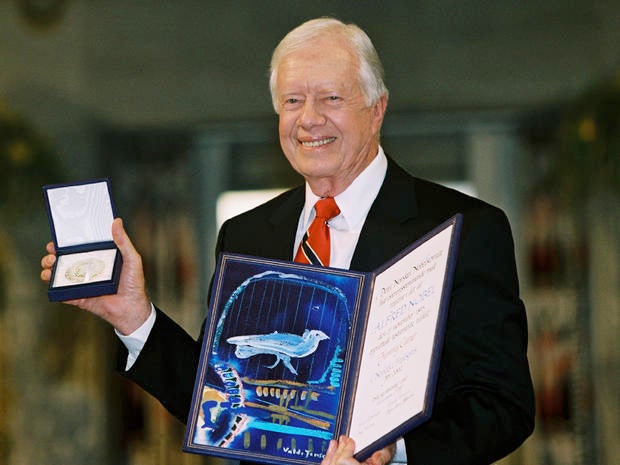 Former President Jimmy Carter holds up his Nobel Peace Prize at a ceremony in Oslo, Norway, on Dec. 10, 2002 