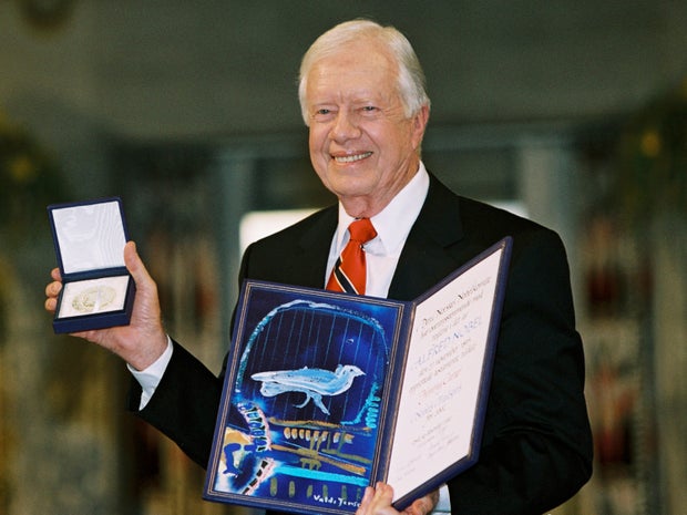 Former President Jimmy Carter holds up his Nobel Peace Prize at a ceremony in Oslo, Norway, on Dec. 10, 2002