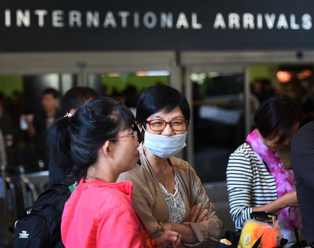 A passenger arrives wearing a face mask at Los Angeles International Airport 