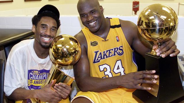 Kobe Bryant (L) of the Los Angeles Lakers holds th 