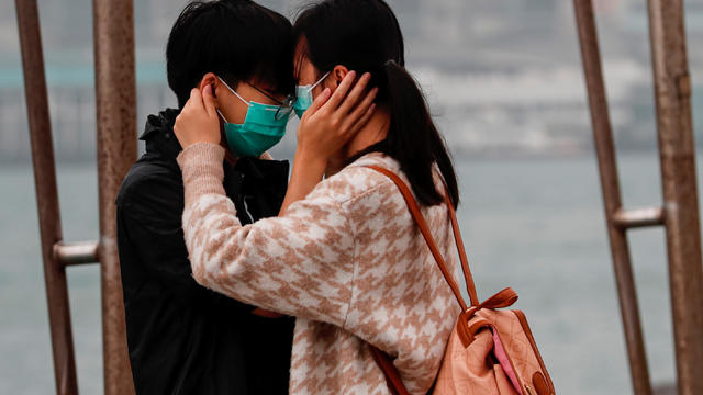 A couple wears masks as the embrace, following the outbreak of the novel coronavirus on Valentine’s Day in Hong Kong 