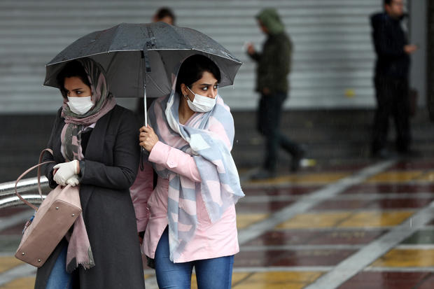 Iranian women wear protective masks to prevent contracting coronavirus, as they walk in the street in Tehran 