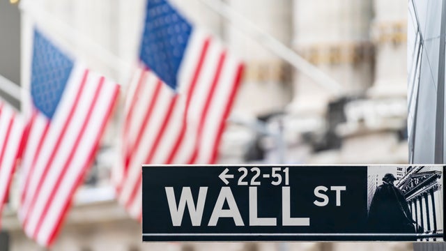 Wall street sign in New York city financial economy and business district with America national flag background. Stock market trade and exchange zone.