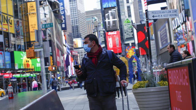 A man in a surgical mask walks by the New York Stock Exchange (NYSE) after more cases of coronavirus were confirmed in New York City, New York 