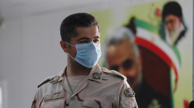 A member of Iranian Border Guards wears a protective face mask, following an outbreak of the new coronavirus, inside the Shalamcha Border Crossing, after Iraq shut a border crossing to travellers between Iraq and Iran 