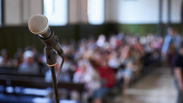 Microphone and abstract blurred conference hall or seminar room background 