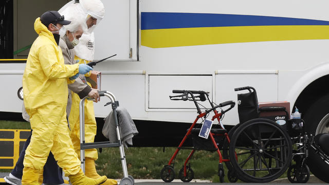 Medical officials aid a residents from St. Joseph's nursing home to board a bus, after a number of residents tested positive for coronavirus disease (COVID-19) in Woodbridge, New Jersey 