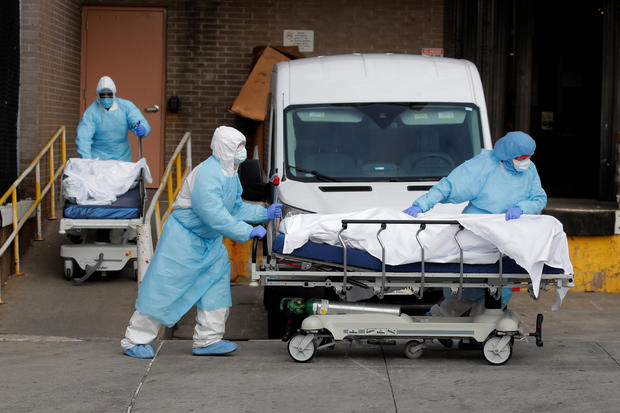 Healthcare workers wheel bodies deceased people from Wyckoff Heights Medical Center during outbreak of coronavirus disease (COVID-19) in New York 