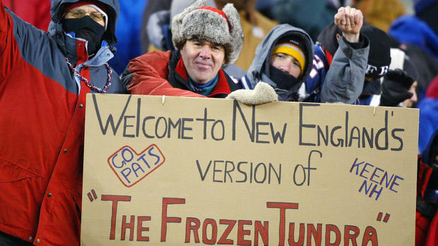 Patriots fans hold a sign 