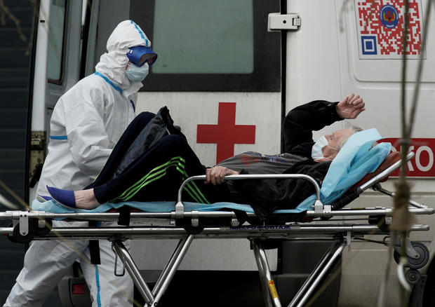 FILE PHOTO: A medical specialist wearing protective gear transports a man on a stretcher outside a hospital for patients infected with the coronavirus disease on the outskirts of Moscow 