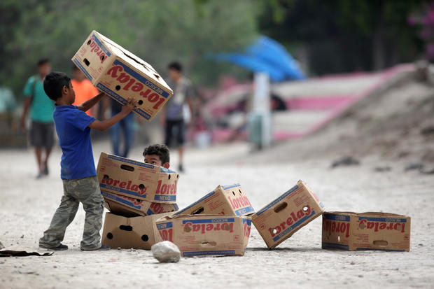 Migrant children play with cardboard boxes at a migrant encampment where more than 2,000 people live while seeking asylum in the U.S., while the spread of Coronavirus disease (COVID-19) continues, in Matamoros 