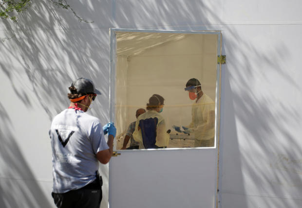 Medical staff from Global Response Management takes samples from a patient suspected of contracting coronavirus disease (COVID-19) at an isolation area of a hospital installed at a migrant encampment in Matamoros 