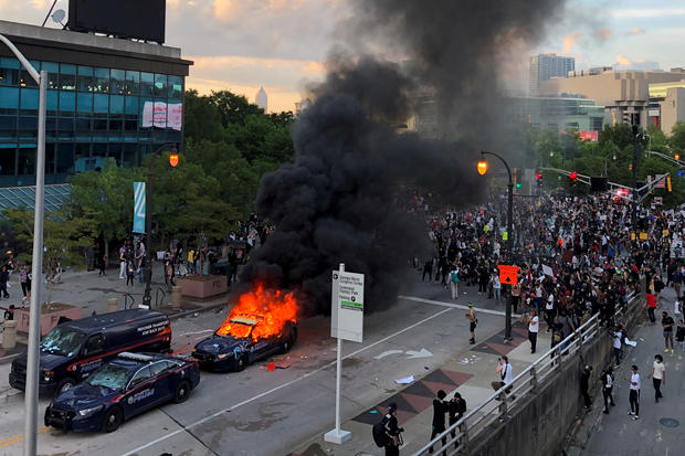 An Atlanta Police car burns as people protest near CNN Center in Atlanta 