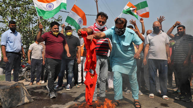 Demonstrators burn a flag resembling Chinese national flag during a protest against China, in Jammu 