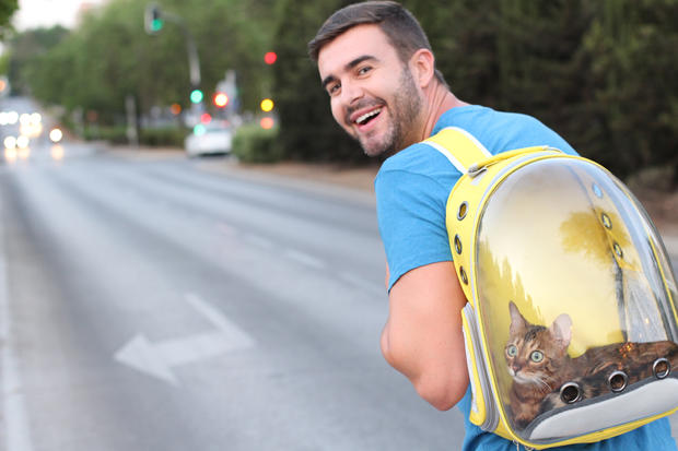 Man using backpack with a porthole for his pet 