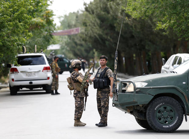 Afghan security forces stand guard near the site of an attack in Kabul, Afghanistan 