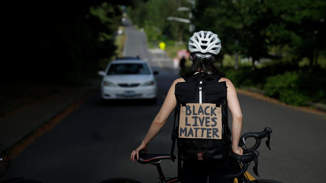 People rally for the defunding of police and reinvestment in community before marching to Seattle Mayor Durkan's home in Seattle 