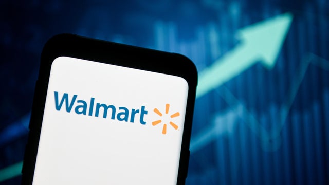 In this photo illustration a Walmart logo seen displayed on