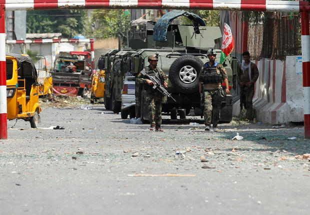 Afghan security forces keep watch in front of the site of an attack on a jail compound in Jalalabad 