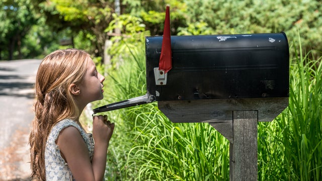 Girl Looking inside a mailbox 