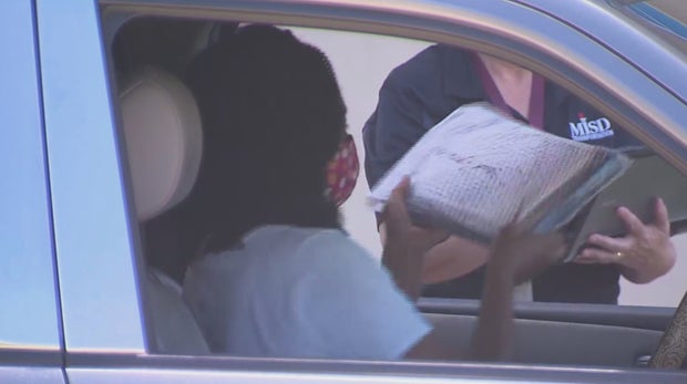 Mansfield ISD parent pick up laptop for her child 