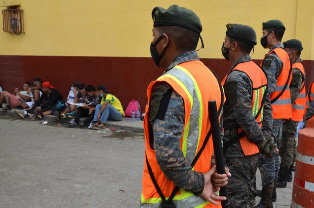 Guatemalan soldiers form a line to prevent a group of Honduran migrants who are trying to reach the U.S, from moving towards the Guatemala and Mexico border, as they sit outside the migrant shelter , in Tecun Uman