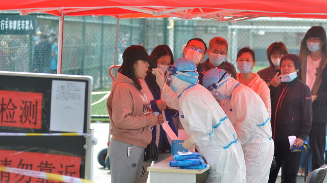 Medical workers in protective suits collect swabs for nucleic acid tests in Qingdao 