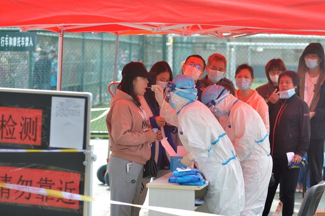 Medical workers in protective suits collect swabs for nucleic acid tests in Qingdao 