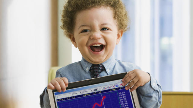 Mixed Race baby holding laptop with graph 