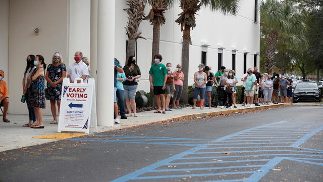 People line up at a polling station as early voting begins in Florida 