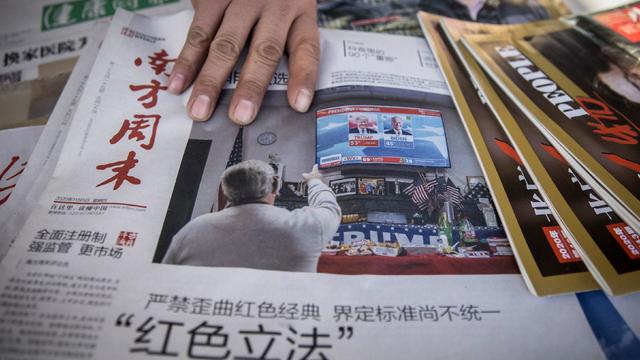 The front page of the Southern Weekly newspaper shows a picture of U.S. President Donald Trump and President-elect Joe Biden at a news stand in Beijing 