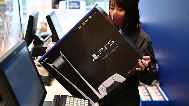 Masked cashier ringing up a Sony PlayStation 5 